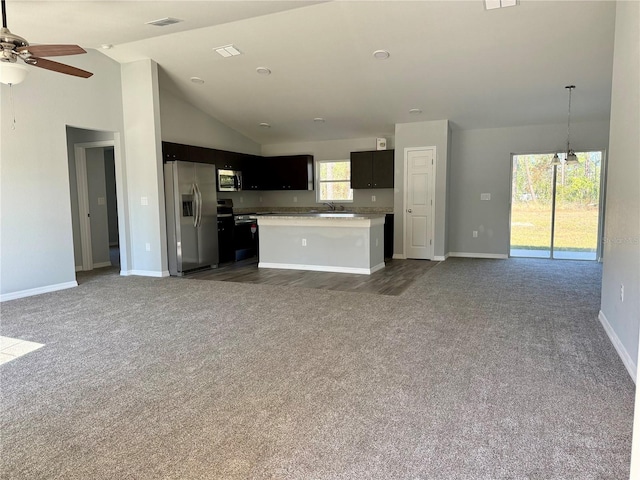 kitchen with ceiling fan, dark carpet, appliances with stainless steel finishes, and a center island