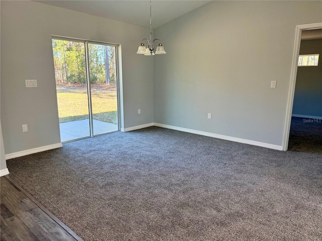 carpeted empty room featuring a notable chandelier