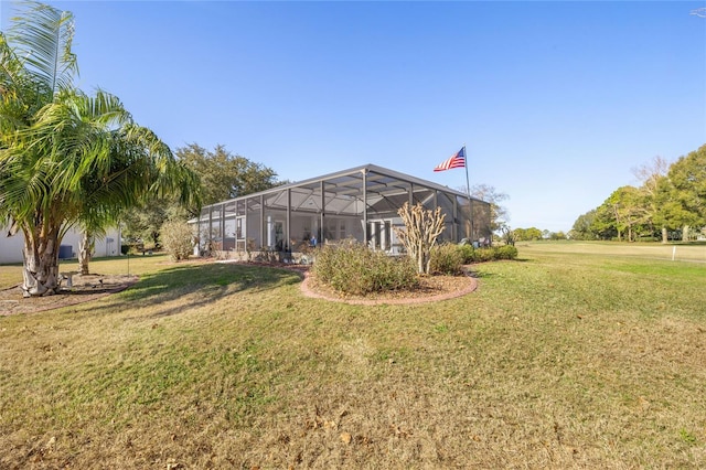 exterior space with glass enclosure and a yard