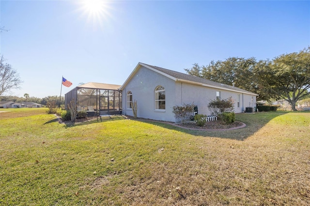 view of side of home featuring a lanai, central AC unit, and a yard