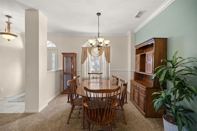 dining space with an inviting chandelier, ornamental molding, and light colored carpet