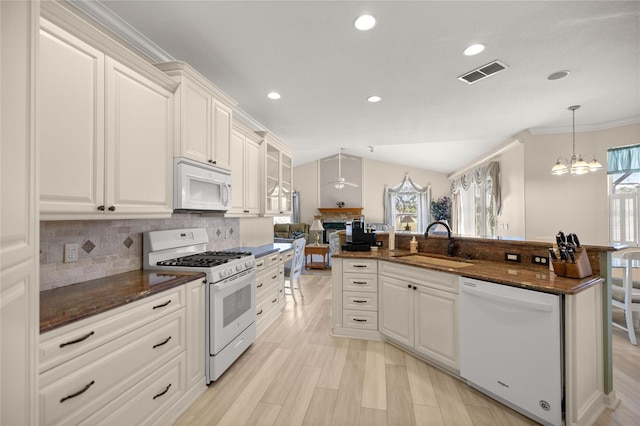 kitchen with white appliances, white cabinetry, and sink