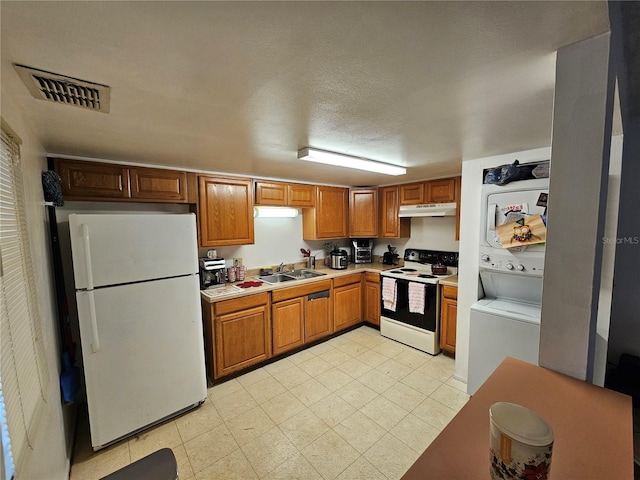 kitchen featuring white appliances, a textured ceiling, and sink