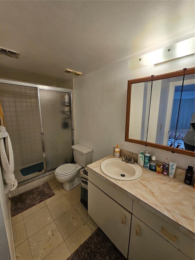 bathroom featuring toilet, an enclosed shower, a textured ceiling, and vanity