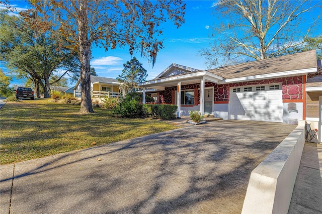 single story home featuring a front yard, covered porch, and a garage