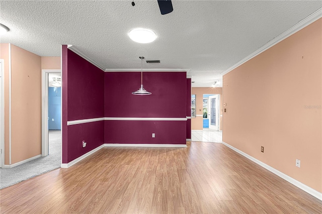 empty room with ceiling fan, ornamental molding, a textured ceiling, and hardwood / wood-style floors