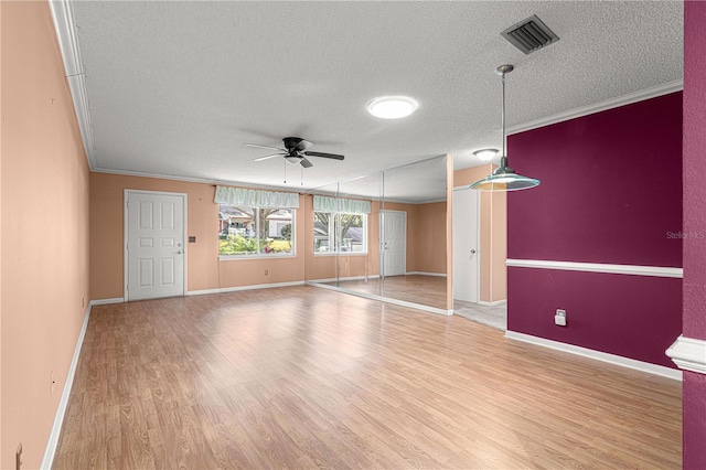 interior space with ceiling fan, light wood-type flooring, crown molding, and a textured ceiling