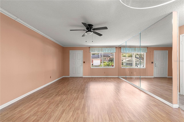 unfurnished living room featuring a textured ceiling, ceiling fan, ornamental molding, and hardwood / wood-style flooring