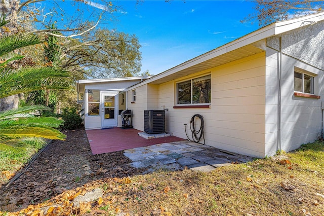 exterior space featuring central AC unit, a patio area, and a sunroom