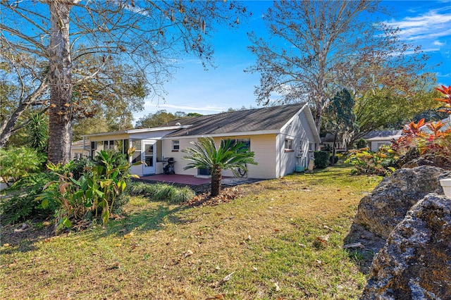 rear view of house featuring a lawn and a patio area