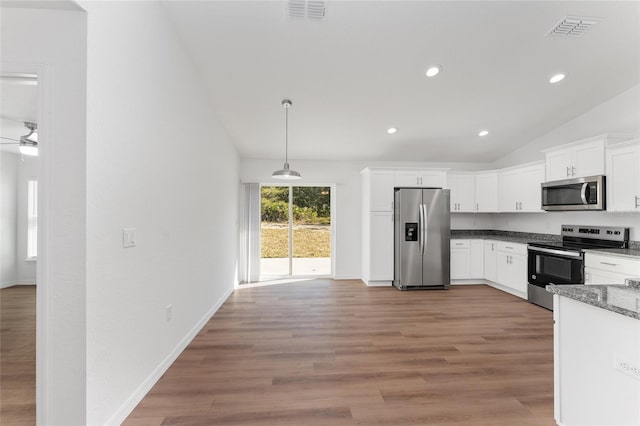 kitchen with vaulted ceiling, pendant lighting, stainless steel appliances, white cabinets, and wood-type flooring