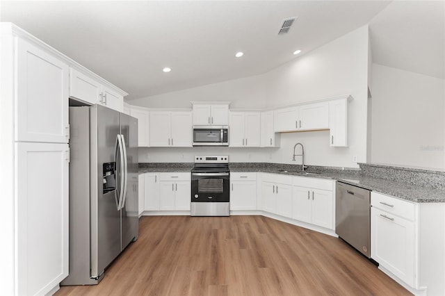 kitchen featuring light stone counters, stainless steel appliances, white cabinetry, and sink