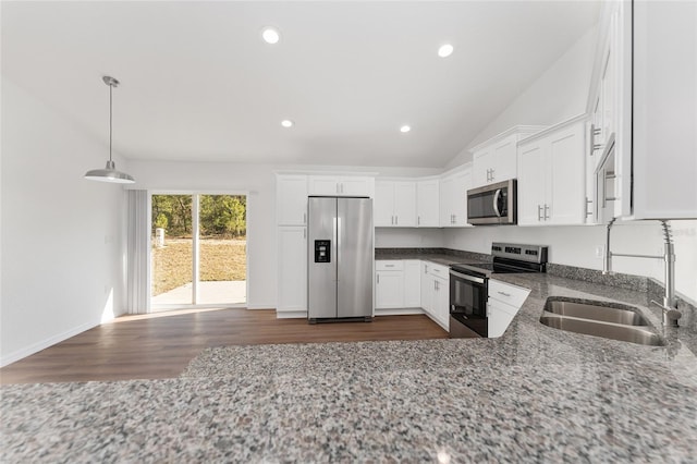 kitchen featuring pendant lighting, white cabinetry, appliances with stainless steel finishes, dark stone countertops, and sink