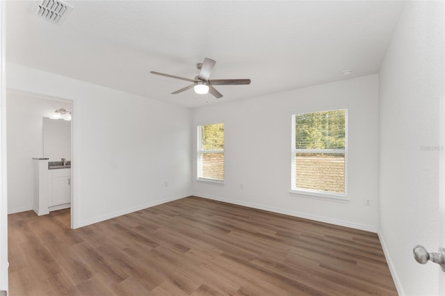 unfurnished room with ceiling fan, hardwood / wood-style floors, and plenty of natural light