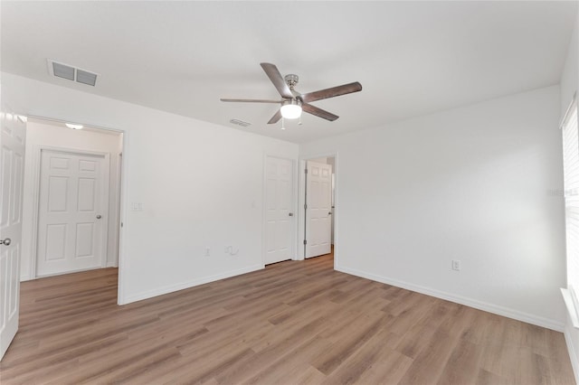 spare room with ceiling fan and light wood-type flooring