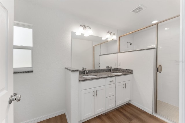 bathroom with an enclosed shower, vanity, and wood-type flooring