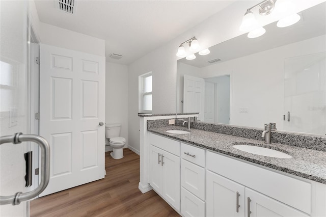 bathroom with toilet, wood-type flooring, and vanity