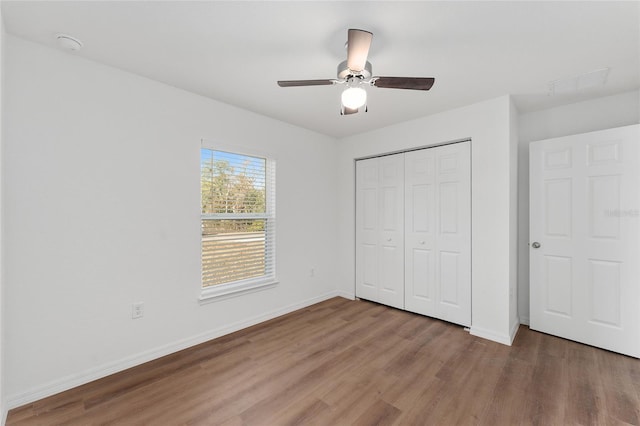 unfurnished bedroom with ceiling fan, hardwood / wood-style floors, and a closet