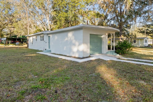 exterior space with a garage, a carport, and a front lawn