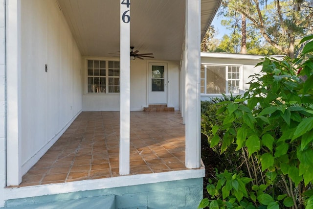 view of exterior entry featuring ceiling fan and a patio area