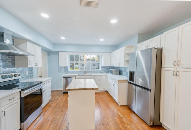 kitchen with stainless steel appliances, a kitchen island, and white cabinets