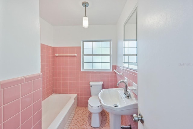 bathroom featuring sink, tile walls, and a bathing tub