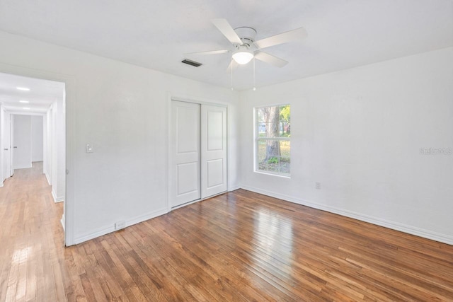 unfurnished bedroom featuring a closet, ceiling fan, and hardwood / wood-style flooring