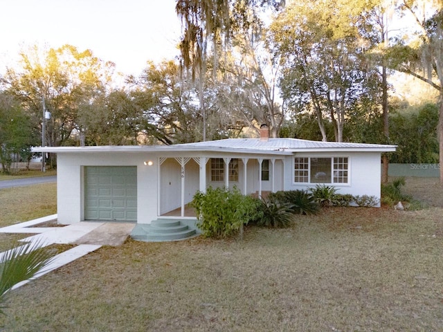 single story home with a front yard and a garage