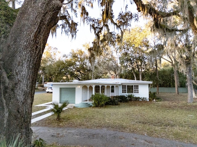 single story home featuring a front yard and a garage