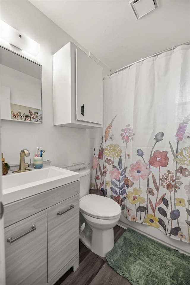 bathroom with a shower with curtain, hardwood / wood-style floors, vanity, and toilet