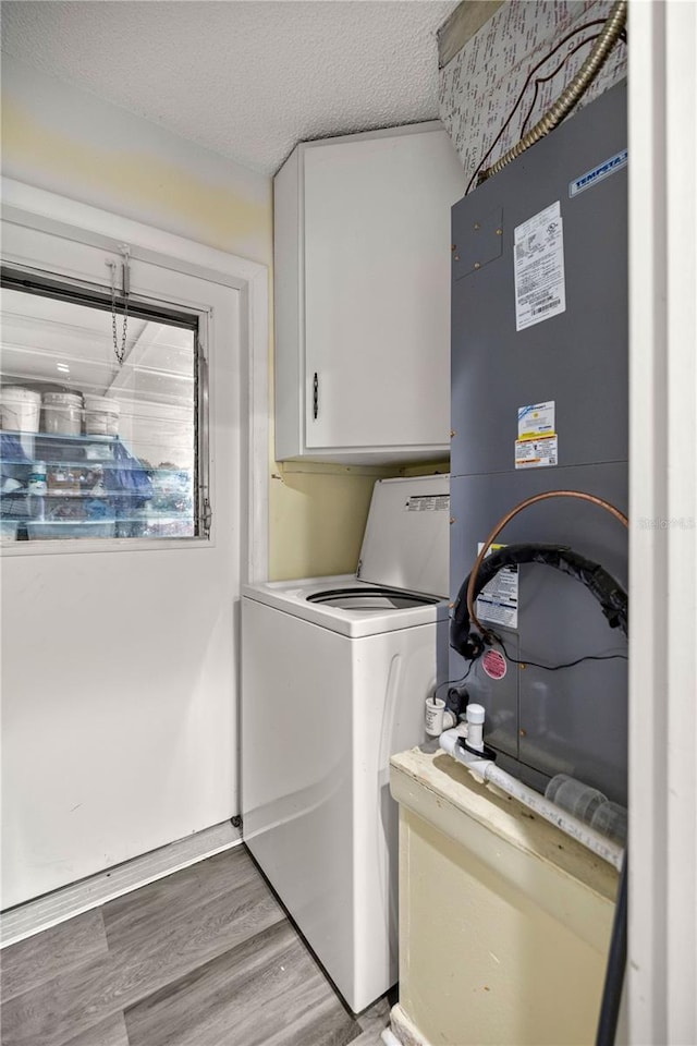 washroom with a textured ceiling, cabinets, washer / dryer, and hardwood / wood-style floors