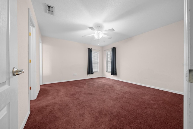 carpeted spare room featuring a textured ceiling and ceiling fan