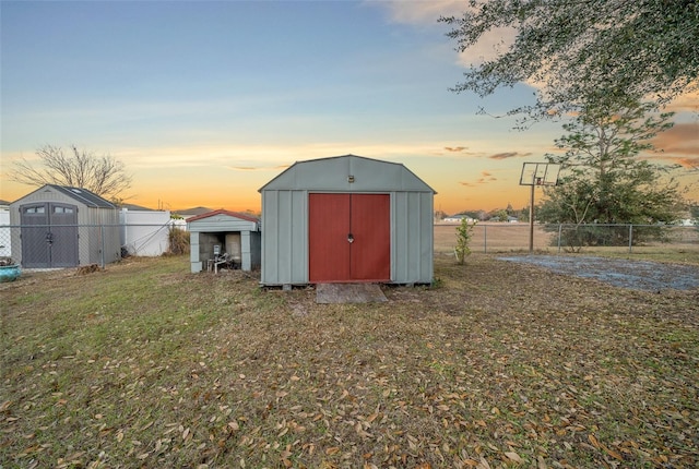 outdoor structure at dusk featuring a lawn