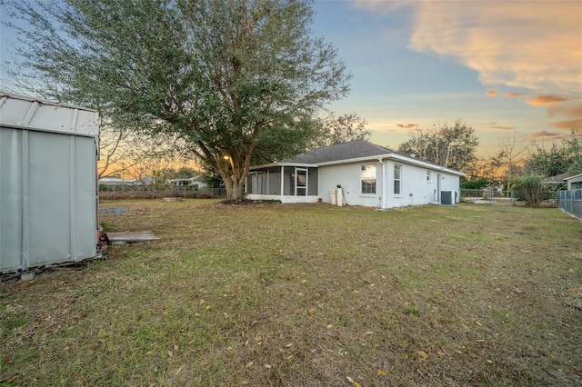 yard at dusk with cooling unit and a sunroom