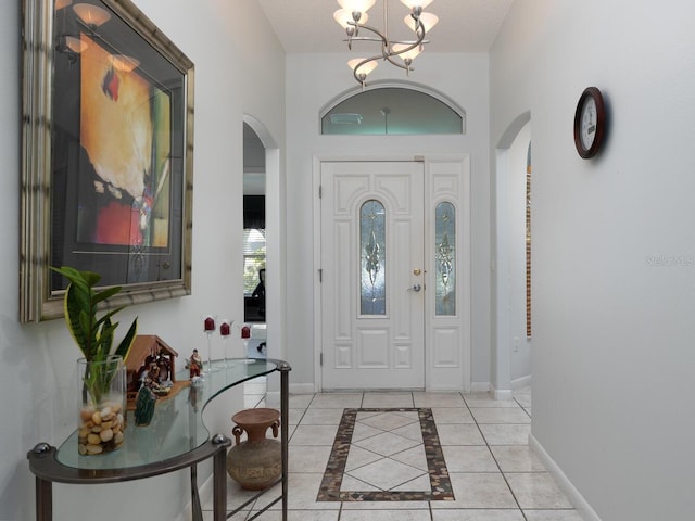 foyer entrance with a textured ceiling, a chandelier, and light tile patterned floors