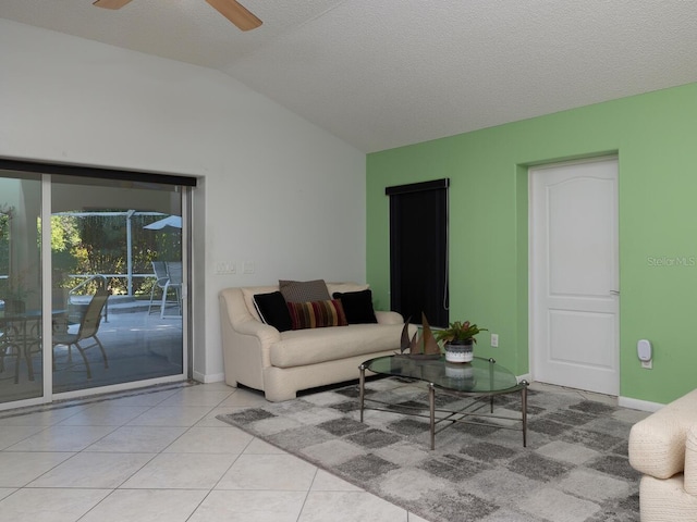 living room with vaulted ceiling, a textured ceiling, ceiling fan, and light tile patterned floors