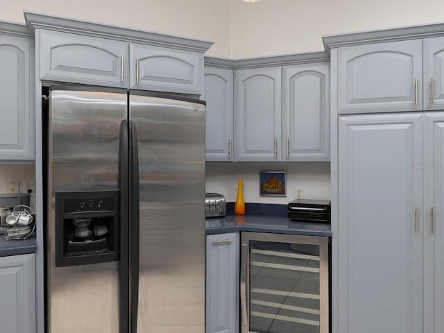 kitchen featuring beverage cooler, stainless steel fridge with ice dispenser, and gray cabinetry