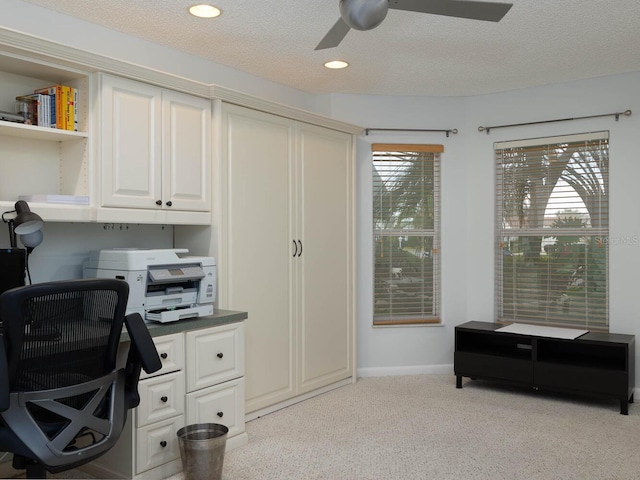 carpeted home office with a textured ceiling, ceiling fan, and plenty of natural light