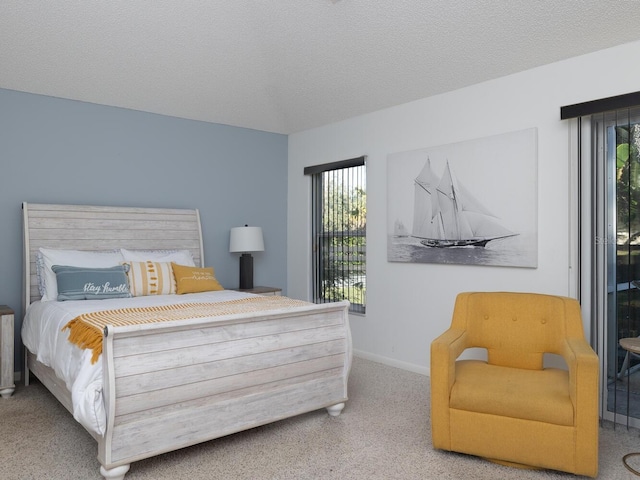 bedroom featuring access to outside, a textured ceiling, and carpet