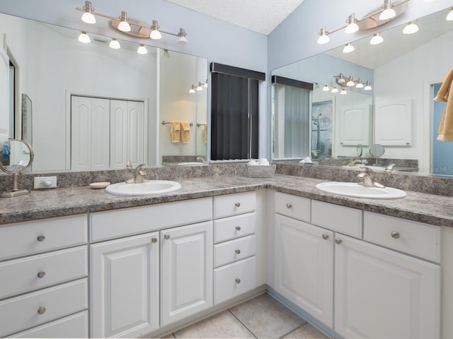 bathroom featuring tile patterned flooring, vanity, and a textured ceiling