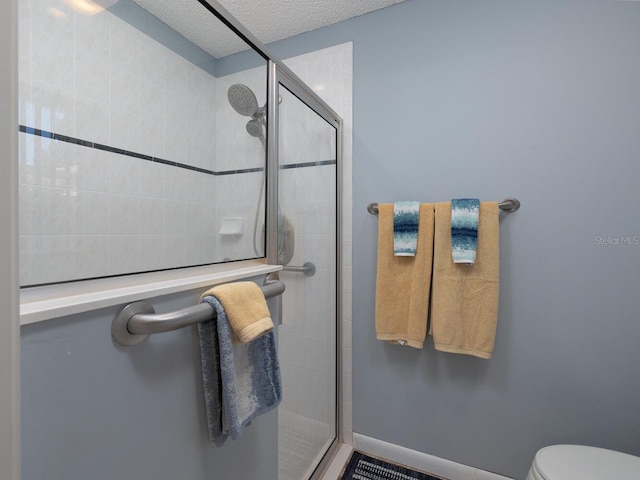 bathroom featuring toilet, a textured ceiling, and walk in shower