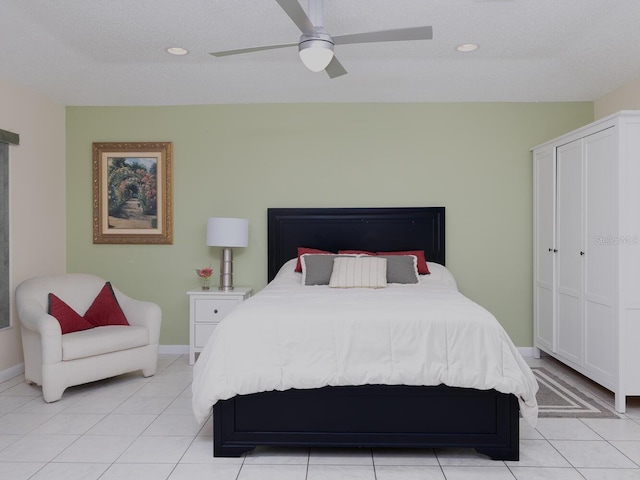 tiled bedroom with ceiling fan and a textured ceiling