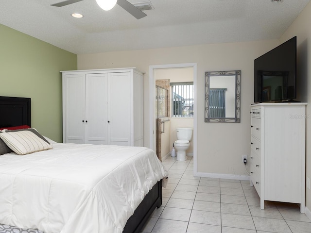 bedroom featuring ensuite bathroom, a textured ceiling, ceiling fan, light tile patterned floors, and a closet