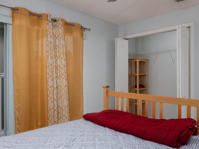 bedroom with a textured ceiling and a closet