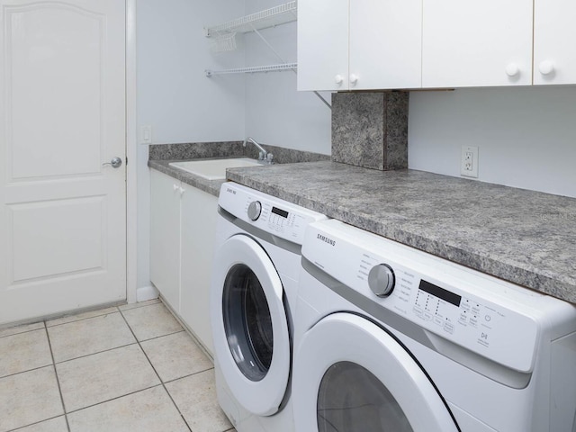 clothes washing area featuring sink, cabinets, light tile patterned flooring, and washing machine and clothes dryer