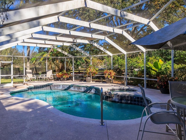 view of pool featuring a patio area, glass enclosure, pool water feature, and an in ground hot tub