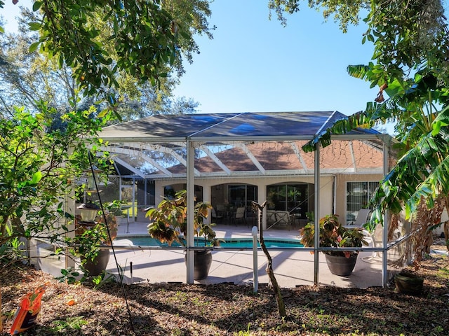 view of swimming pool with glass enclosure and a patio area