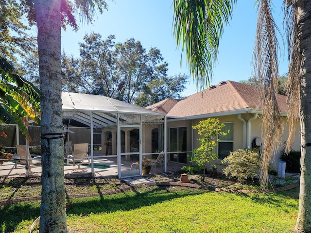 back of property featuring a patio, glass enclosure, and a lawn