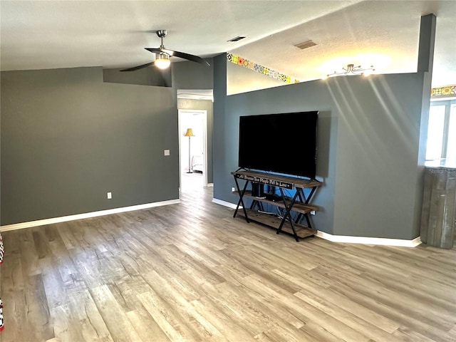 living room with lofted ceiling, a textured ceiling, ceiling fan, and light hardwood / wood-style floors