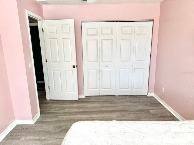 unfurnished bedroom featuring a closet and hardwood / wood-style floors